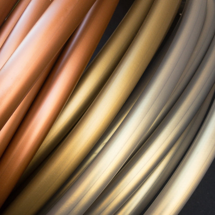 Champagne gold, copper and Cryptic egyptian polypro tubing. Metal gold hoop, pale metallic purple. Stacked hoop coils