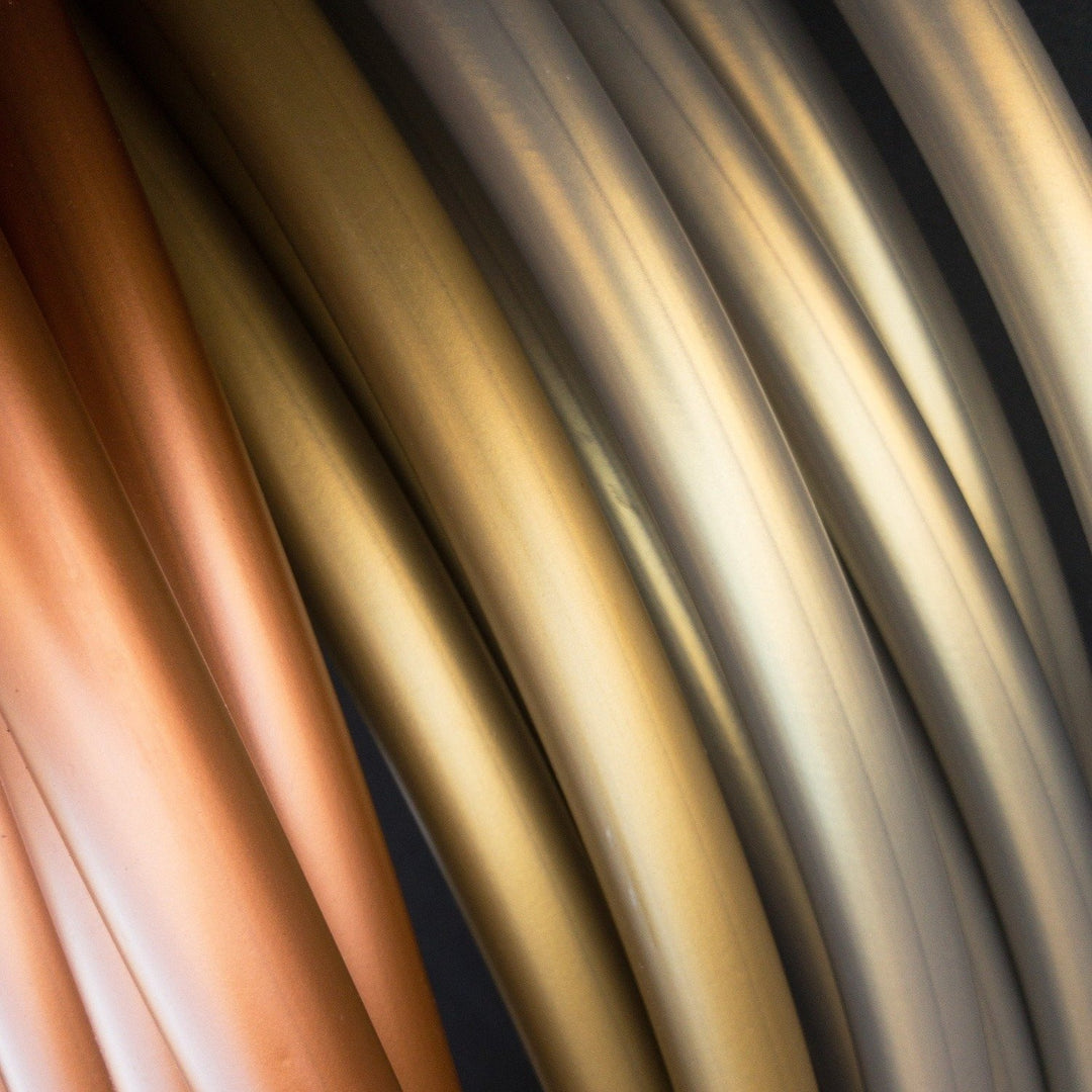 Copper, gold and silver hula hoop coils against a black background